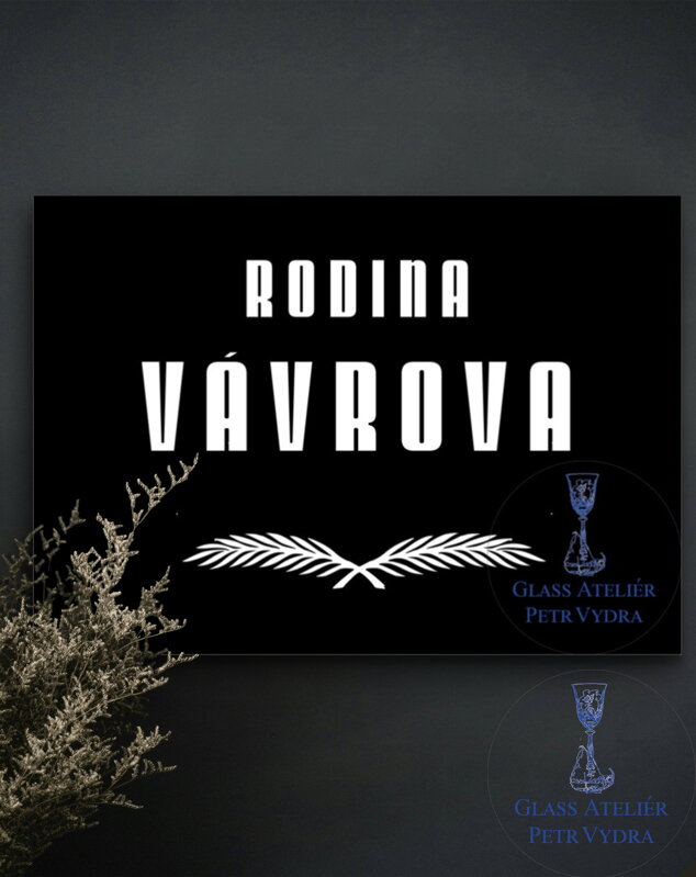 V8. Černá náhrobní skleněná deska s nápisem "RODINA" a pírky