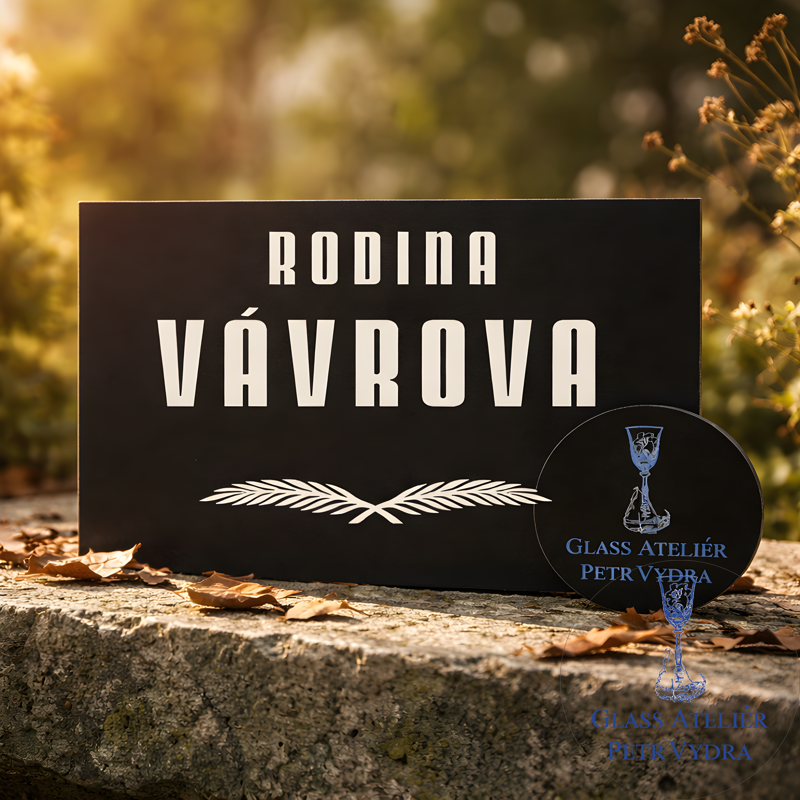 V8. Černá náhrobní skleněná deska s nápisem "RODINA" a pírky